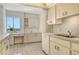 A well-lit kitchen features white cabinetry, tiled floors, and a window view at 20 Whispering Sands Dr # 1201, Sarasota, FL 34242