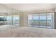 Bright living room with neutral carpet, with an ocean view from large sliding glass doors and mirrored walls at 20 Whispering Sands Dr # 1201, Sarasota, FL 34242