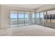 Spacious living room with neutral carpet, with lots of natural light and stunning ocean views from large sliding glass doors at 20 Whispering Sands Dr # 1201, Sarasota, FL 34242