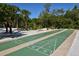Outdoor shuffleboard courts providing recreational opportunities amidst lush tropical surroundings at 20 Whispering Sands Dr # 1201, Sarasota, FL 34242