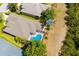 Aerial view of the home with its screened-in pool, lawn, and surrounding greenery at 224 Dahlia Ct, Bradenton, FL 34212