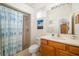 Bright bathroom featuring one sink with wooden cabinet, toilet, and shower-tub combo at 224 Dahlia Ct, Bradenton, FL 34212