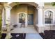 Inviting front porch featuring classic columns, a water fountain, seating, and a blue front door at 224 Dahlia Ct, Bradenton, FL 34212