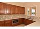 Charming kitchen with custom cabinets, modern microwave, stone countertops, mosaic backsplash and stainless steel sink at 224 Dahlia Ct, Bradenton, FL 34212