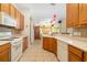 Well-lit kitchen features wood cabinets, tile backsplash, and appliances, leading into a cozy living area at 224 Dahlia Ct, Bradenton, FL 34212