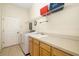 Bright laundry room with wood cabinets, sink, storage shelf, and appliances at 224 Dahlia Ct, Bradenton, FL 34212