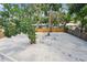 Backyard featuring a large crushed stone area surrounded by a wooden fence and lush trees at 2655 Bay St, Sarasota, FL 34237