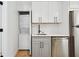 Bright kitchen with white upper cabinets, stainless steel appliances and a stacked washer/dryer in the background at 2655 Bay St, Sarasota, FL 34237