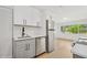 Well-lit kitchen with white cabinets, stainless steel appliances, and an adjacent living space at 2655 Bay St, Sarasota, FL 34237
