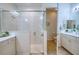 Bright bathroom featuring tiled shower with glass door, double vanity, and a toilet in a separate space at 2945 Trustee Ave, Sarasota, FL 34243