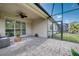 Screened in patio with brick pavers, ceiling fan, and sliding glass door to the home's interior at 2945 Trustee Ave, Sarasota, FL 34243