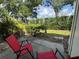 Outdoor patio seating with serene views of the lush, green lawn and mature trees at 3002 Sail Pointe Cir # 1B, Venice, FL 34293