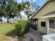 View of backyard with lush foliage, screen porch, and brick paving at 3002 Sail Pointe Cir # 1B, Venice, FL 34293
