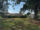 Spacious backyard with lush green grass and mature trees offering shade at 3002 Sail Pointe Cir # 1B, Venice, FL 34293