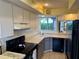 Well-lit kitchen with ample white cabinets, black appliances, and a garden window offering a peaceful view at 3002 Sail Pointe Cir # 1B, Venice, FL 34293