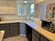 Cozy kitchen featuring two-tone cabinets, stainless steel appliances, and a bright window with charming shutters at 3002 Sail Pointe Cir # 1B, Venice, FL 34293
