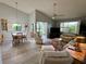 Bright living room featuring vaulted ceilings, a ceiling fan, hardwood floors, and an adjacent dining area at 3002 Sail Pointe Cir # 1B, Venice, FL 34293
