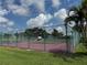 Well-maintained tennis court surrounded by lush greenery and secure fencing, perfect for recreational enjoyment at 3002 Sail Pointe Cir # 1B, Venice, FL 34293