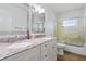 Bathroom featuring double sink vanity and tub with glass shower doors at 3105 Gulfgate Dr, Sarasota, FL 34231