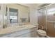 Bathroom featuring a vanity with a marbled countertop and glass shower doors at 3105 Gulfgate Dr, Sarasota, FL 34231