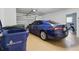 Garage with new blue sedan parked inside and recycle bins in the corner at 3105 Gulfgate Dr, Sarasota, FL 34231