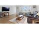 Bright living room with a large window, hardwood floors, and comfortable seating with a coffee table on an area rug at 3105 Gulfgate Dr, Sarasota, FL 34231