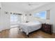 Bright main bedroom featuring wood floors, a ceiling fan, and sliding door access to an enclosed lanai at 3105 Gulfgate Dr, Sarasota, FL 34231