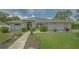 Charming single-story home with manicured lawn and lush landscaping, creating inviting curb appeal at 4037 Wooley Ave, North Port, FL 34287