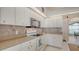 Well-lit kitchen featuring stone tile backsplash, granite countertops and white cabinetry at 4037 Wooley Ave, North Port, FL 34287
