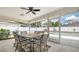 Screened lanai with a dining table and view of the pool and white fence at 4037 Wooley Ave, North Port, FL 34287