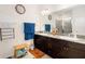 Bathroom with dual sinks, granite countertops, a walk-in shower, and dark wood cabinets at 4119 Mossy Limb Ct, Palmetto, FL 34221