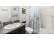 Bathroom featuring a granite vanity top, white tiled walls, and a decorative shower curtain at 4119 Mossy Limb Ct, Palmetto, FL 34221
