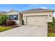 Inviting exterior view of home featuring a two-car garage, manicured lawn, and lush landscaping at 4119 Mossy Limb Ct, Palmetto, FL 34221