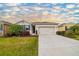 Charming single-story home featuring a two-car garage, well-maintained lawn, and tropical landscaping at 4119 Mossy Limb Ct, Palmetto, FL 34221
