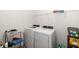 Efficient laundry room with modern washer and dryer, plus shelving for organized storage at 4119 Mossy Limb Ct, Palmetto, FL 34221