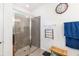 Bathroom featuring tiled shower with glass door, towel racks, clock, and a bench at 4119 Mossy Limb Ct, Palmetto, FL 34221