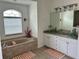 Primary bathroom with a separate tub, a granite countertop, and ample natural light at 4217 N Chamberlain E Blvd, North Port, FL 34286