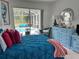 Comfortable bedroom with a large bed, a dresser, and sliding glass doors to screened pool at 4217 N Chamberlain E Blvd, North Port, FL 34286