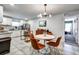 Bright kitchen and dining area with white cabinetry, stainless steel appliances, and a modern chandelier at 4542 19Th S Ave, St Petersburg, FL 33711