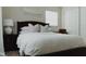 Cozy bedroom boasts a dark wood bed, white bedding, and a stylish white ceramic table lamp at 4549 Mcintosh Ln, Sarasota, FL 34232