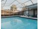 Relaxing in-ground pool area with screened enclosure, privacy fence, and lounge chairs at 4549 Mcintosh Ln, Sarasota, FL 34232