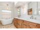 Elegant bathroom with a soaking tub, double vanities, and modern lighting fixtures at 4625 Deer Creek Blvd, Sarasota, FL 34238