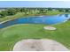 Aerial view of pristine golf course with mature landscaping, a serene lake and sand traps for avid golfers to enjoy at 4625 Deer Creek Blvd, Sarasota, FL 34238
