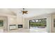 Open living room with fireplace, ceiling fan and access to screened pool area at 4625 Deer Creek Blvd, Sarasota, FL 34238