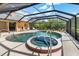Screened-in pool with attached hot tub, patio seating, and a lush green perimeter at 4625 Deer Creek Blvd, Sarasota, FL 34238