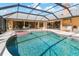 Screened in pool and hot tub with view of home's interior through sliding glass doors at 4625 Deer Creek Blvd, Sarasota, FL 34238