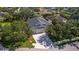 Bird's-eye view of a property with a gray roof, mature trees, and a long driveway in a residential neighborhood at 4712 Charles Partin Dr, Parrish, FL 34219