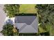 Aerial view of a well-maintained gray roof, set amidst mature trees and manicured landscaping at 4712 Charles Partin Dr, Parrish, FL 34219