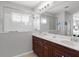 Bathroom vanity with dual sinks, framed mirror reflecting tile shower, and neutral color palette at 4712 Charles Partin Dr, Parrish, FL 34219