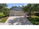 Inviting single-story home showcases a spacious driveway, a three-car garage, and lush greenery around the property at 4712 Charles Partin Dr, Parrish, FL 34219